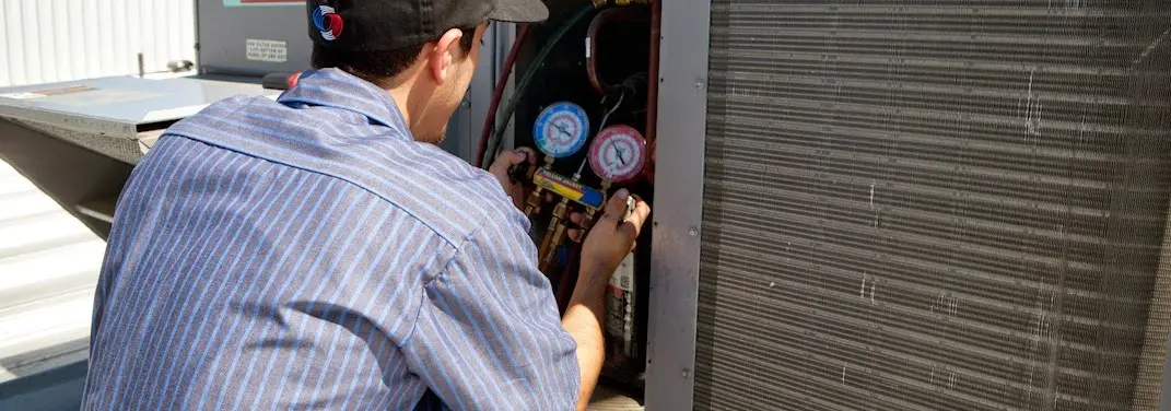 HVAC technician servicing a condenser unit in Clearlake